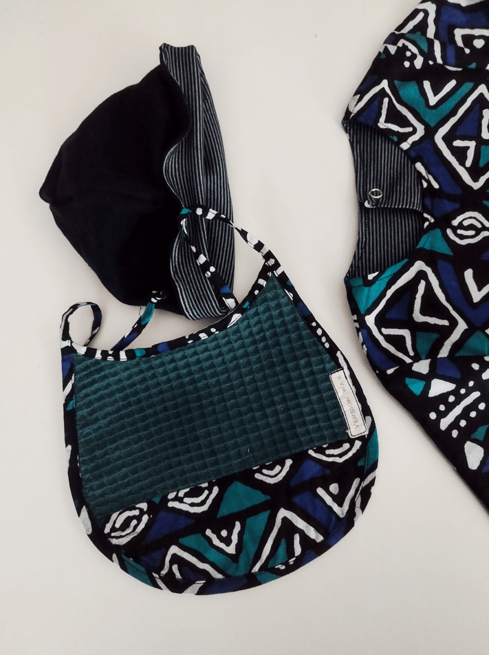 ensemble cadeau de naissance représente un bavoir, un bonnet et un pyjama bleu