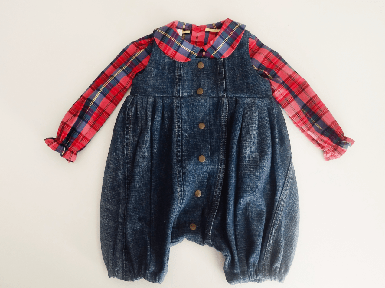 barboteuse en jean délavé bleu porté sur une chemise à carreaux rouge et bleue