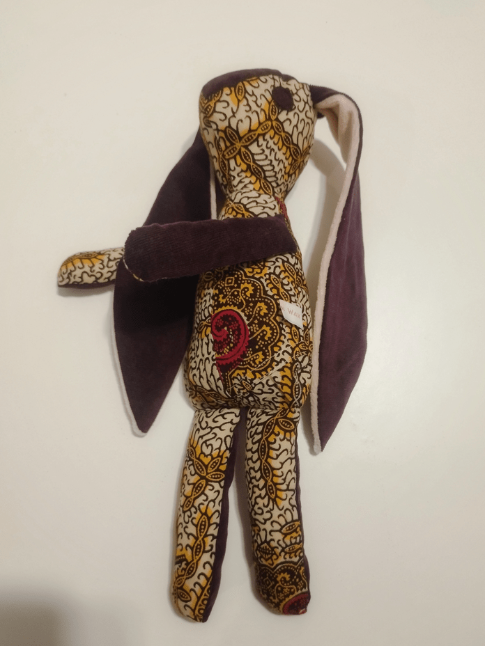 doudou animal en forme de lapin avec des longues oreilles de couleur rouge et orange