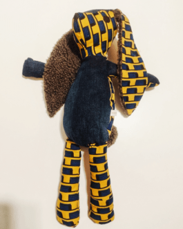 Doudou lapin en Wax africain représentant un damier bleu sur fond jaune. Il s'agit d'un lapin en tissu avec des grandes oreilles doublées de tissu duveteux. le ventre et les pattes avant sont en Denim