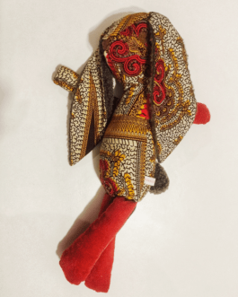 Doudou en forme de lapin en tissu wax de couleur orange, il a des pattes en velours milleraies et le corps en imprimé