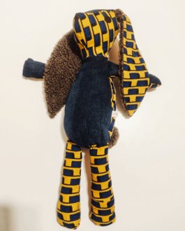 Doudou lapin en Wax africain représentant un damier bleu sur fond jaune. Il s'agit d'un lapin en tissu avec des grandes oreilles doublées de tissu duveteux. le ventre et les pattes avant sont en Denim