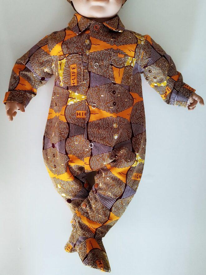 mannequin bébé portant une combinaison en wax orange avec des chaussons assortis