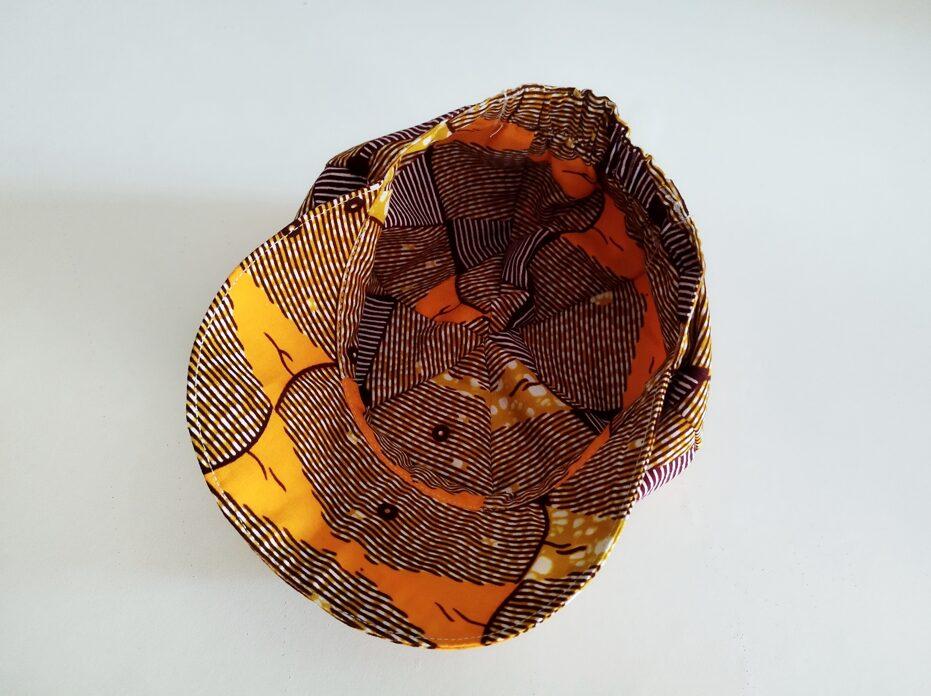 intérieur de casquette pour bébé , le tissu est imprimé à la cire (Wax) et de couleur orange majoritairement