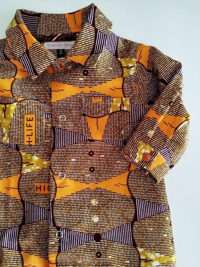 détail col et manche de combinaison pour bébé orange en tissu africain