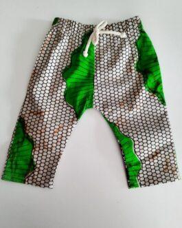 pantalon pour bébé en tissu wax imprimé vert sur fond beige posé à plat