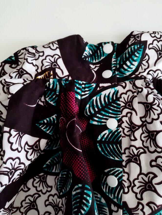 détail du dos d'une blouse en wax imprimée pour bébé, les pressions rondes sont blanches