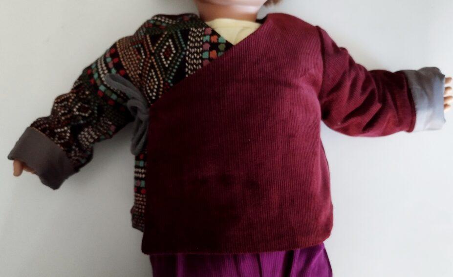Veste en velours bordeaux pour bébé porté sur un mannequin de taille 6 mois