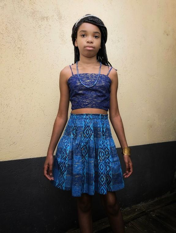 jeune fille qui porte un ensemble en Kente doré et bleu marine