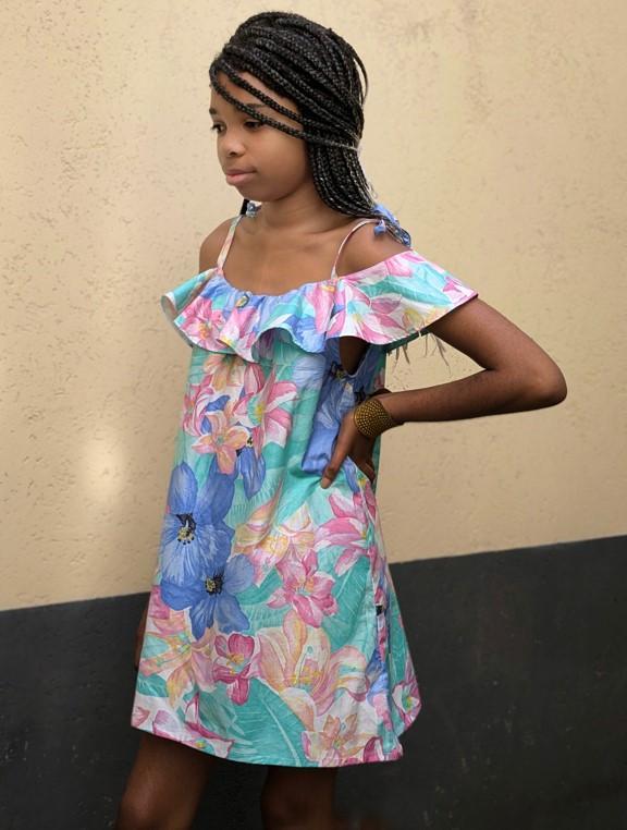 Fillette qui porte une robe fleurie dans les tons pastels