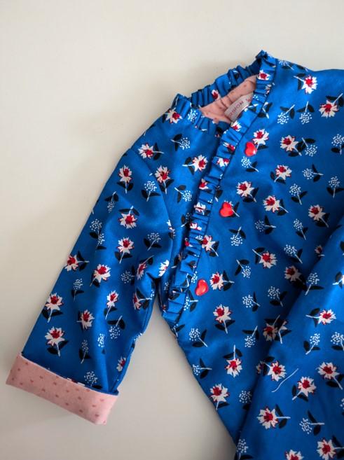 détail de la combinaison pour bébé fille fleurie avec le revers sur la manche