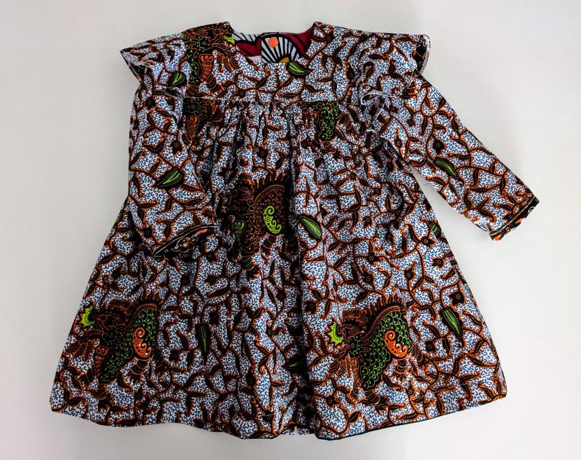 robe en wax vivi pour bébé fille, l'imprimé se compose de feuilles verts et beiges avec des touches de marron
