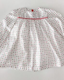 robe pour bébé, elle est blanche avec des motifs rouges