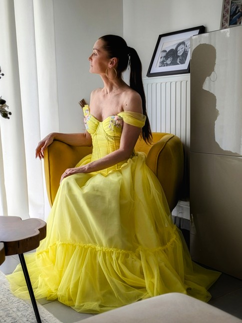 femme assise portant une robe en tulle jaune