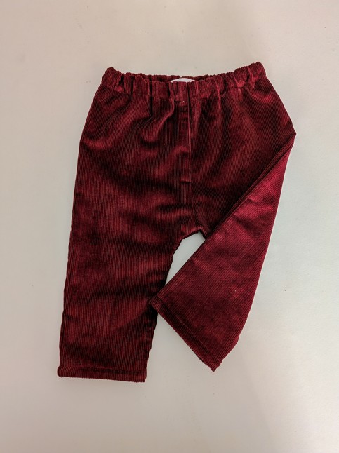 pantalon en velours bordeaux pour bébé avec une jambe repliée