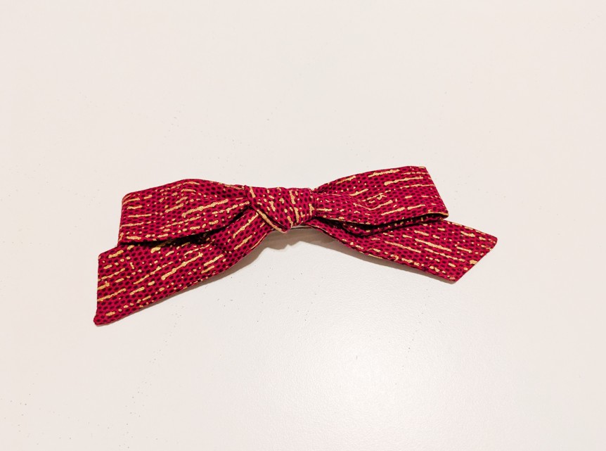 Pince à cheveux en forme de nœud papillon de couleur rouge et doré