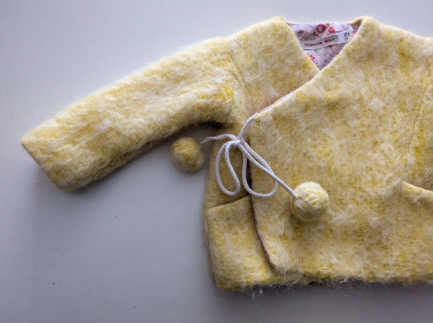 détail des pompons de la veste pour bébé