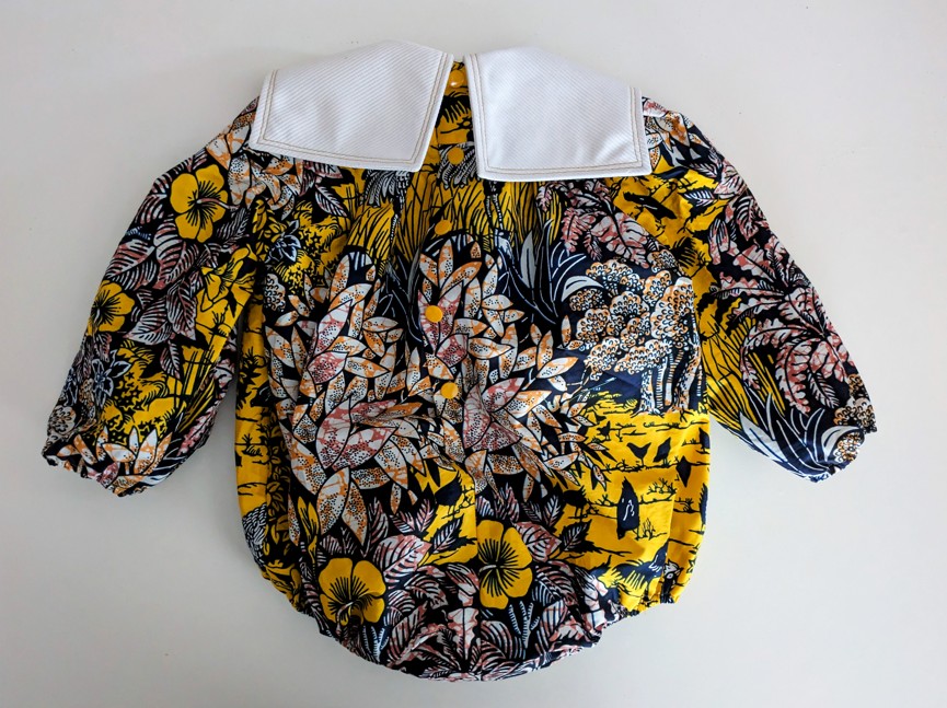 Body pour bébé en wax imprimé village Molokoi jaune avec un col blanc vue de dos